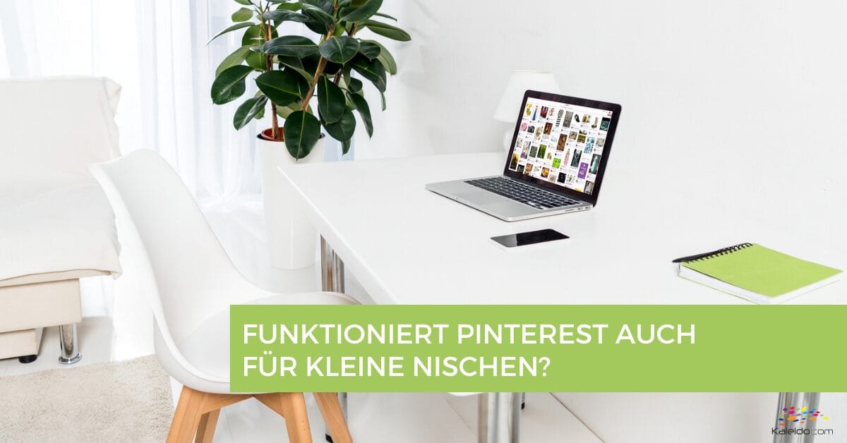 Ein moderner weißer Arbeitsbereich mit einem Laptop, der Pinterest anzeigt, einem grünen Notizbuch, einem Stift, einer Pflanze und einem Stuhl. Der eingeblendete Text auf Deutsch fragt: "Funktioniert Pinterest auch für kleine Nischen?" - perfekt für die Erkundung jeder Nische.