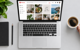 Auf einem weißen Schreibtisch stehen eine Pflanze, ein Bleistift und eine Hand, die eine Tasse Kaffee hält, sowie ein Laptop, auf dem Pinterest zu sehen ist. Der Pinterest-Bildschirm zeigt Bilder von Essen, Dekoration und inspirierenden Motiven – die perfekte Inspiration, wenn du vorhast, deine Pinnwände aufzuräumen und deine Lieblingsideen zu ordnen.